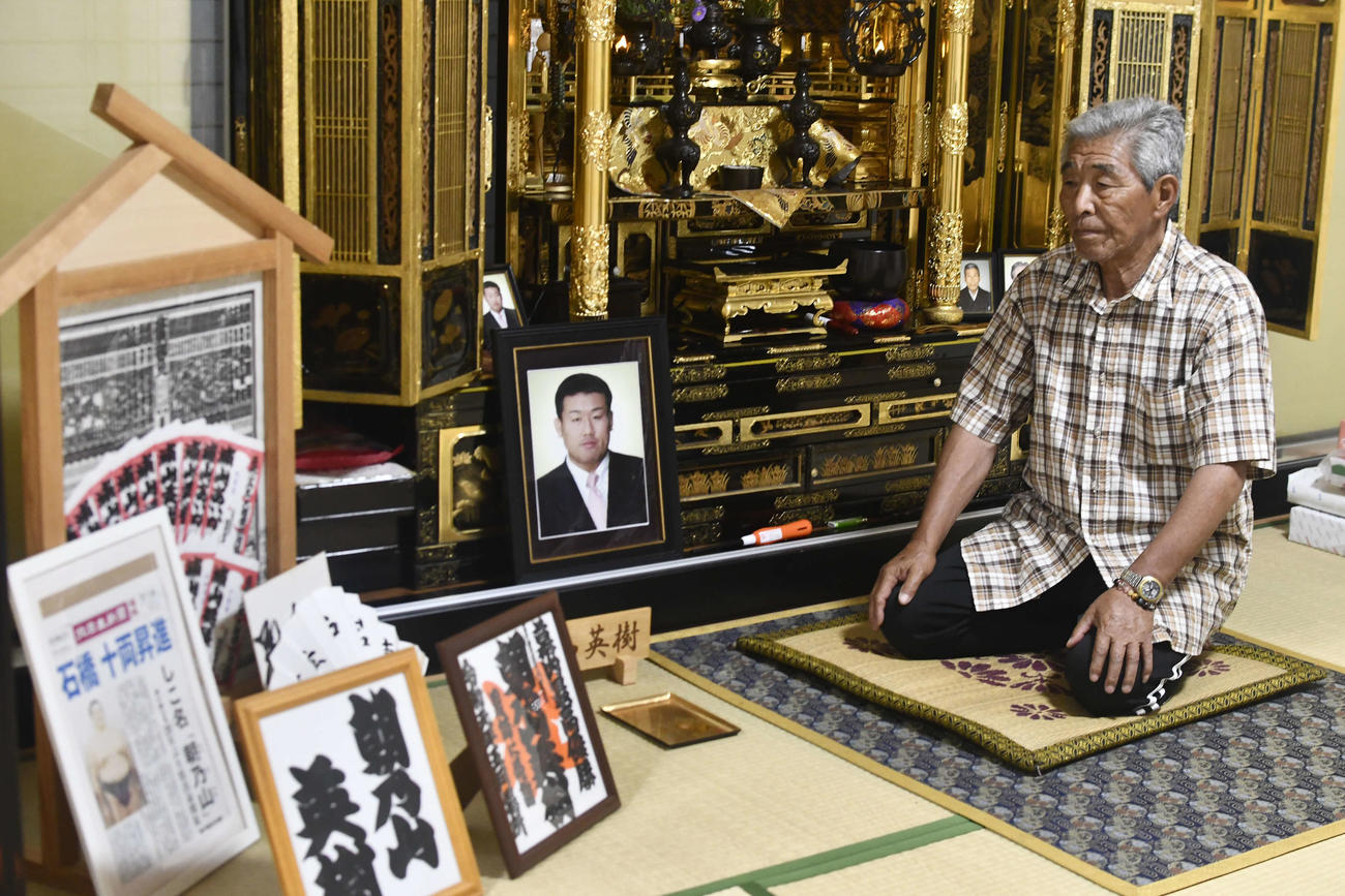 浦山英樹さんの祭壇の前で父松男さんは朝乃山の資料を眺める（撮影・平山連）