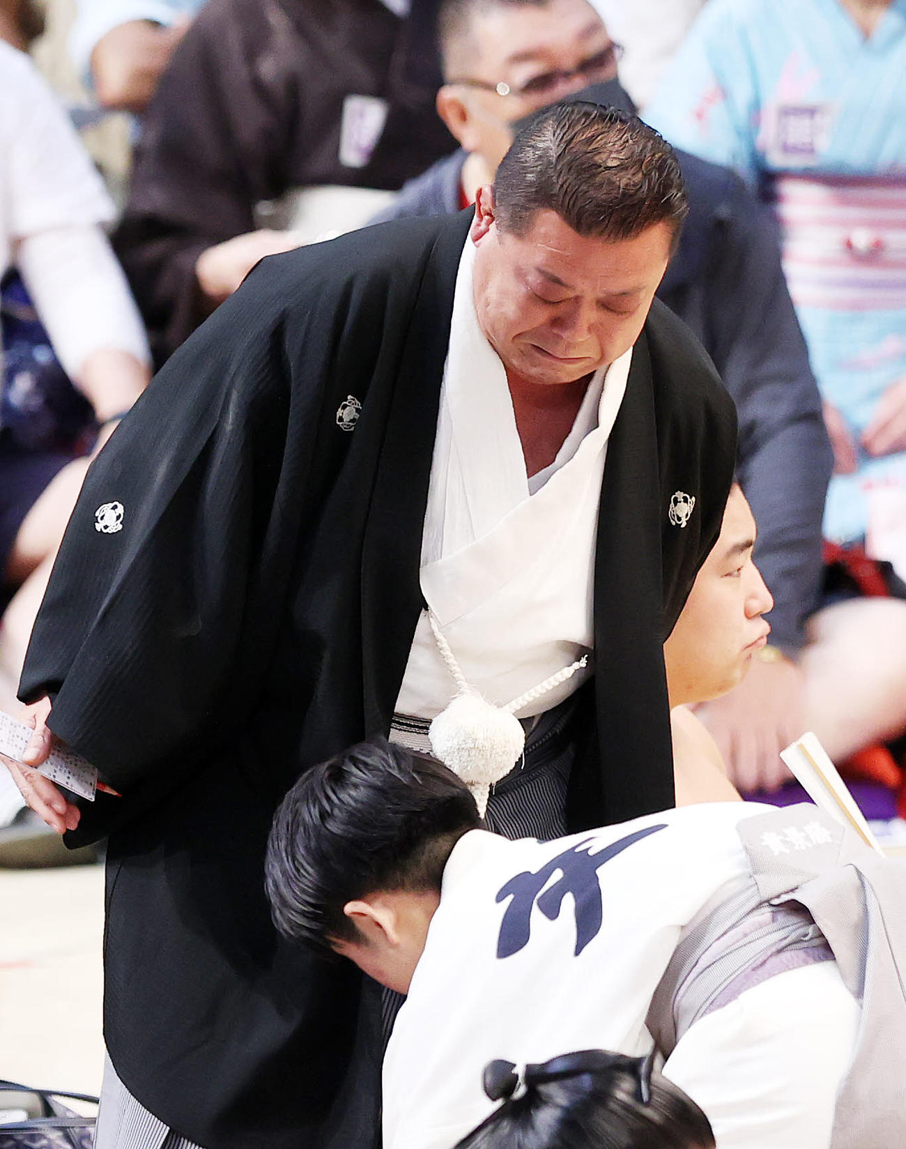 錦木と翔猿が落ちてきて痛そうな表情する玉垣親方（撮影・鈴木正人）