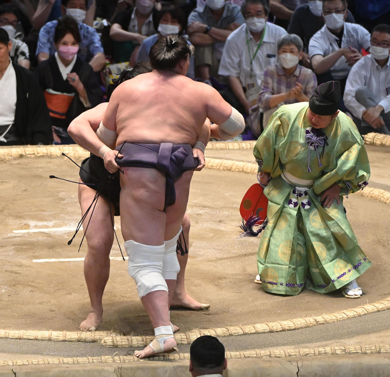 式守伊之助（右）が止めた事に気づかない若元春に寄り切られる照ノ富士（中央・背中）（撮影・森本幸一）