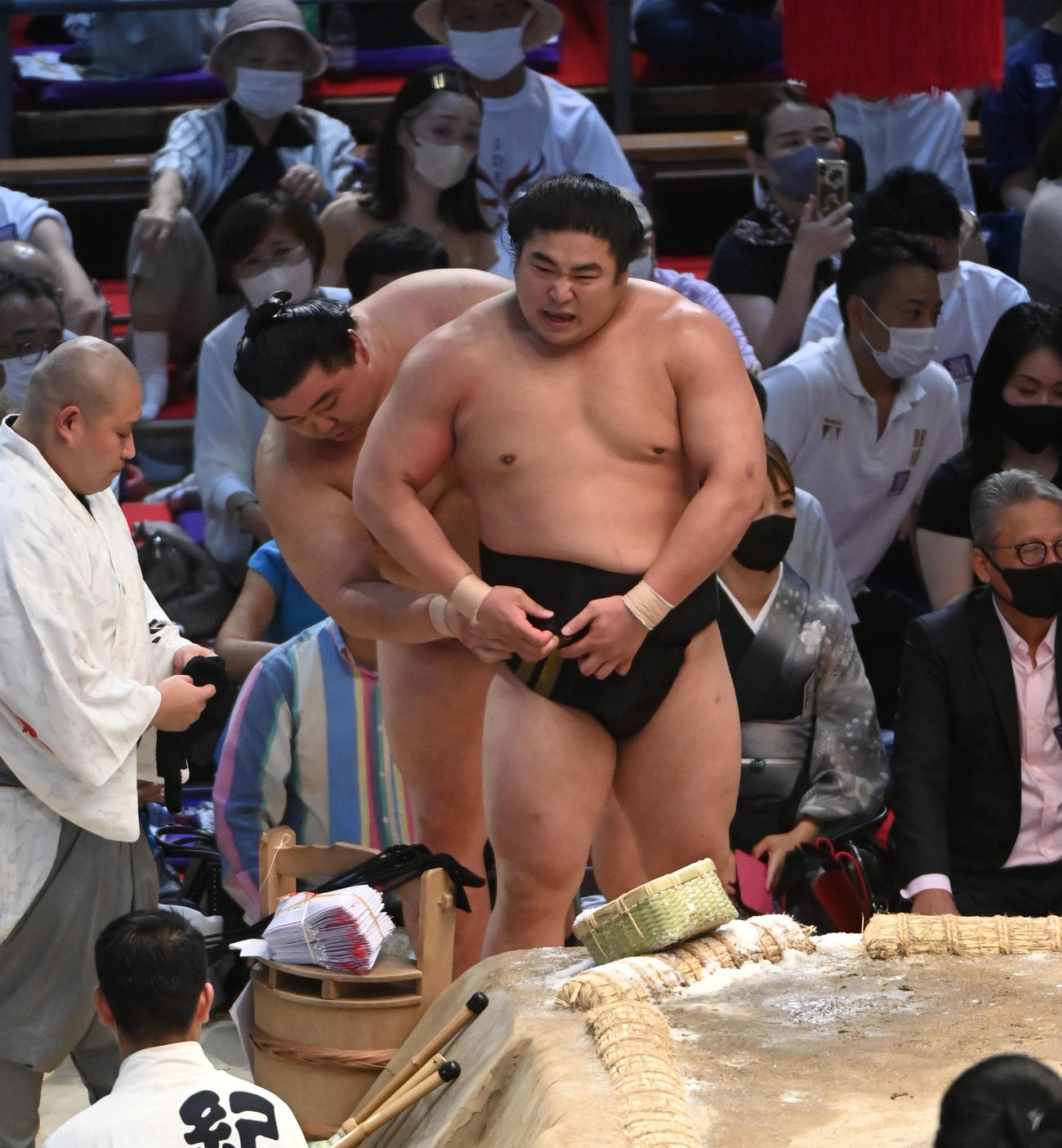 審判団の協議中に正代に手伝ってもらいまわしを締め直す若元春（右）（撮影・森本幸一）