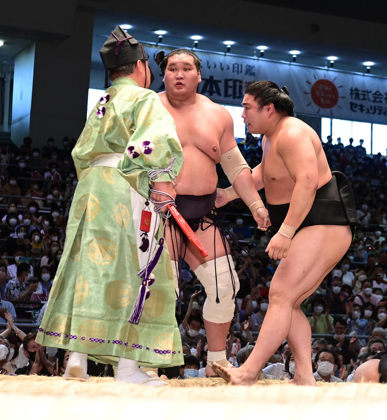俵を割った照ノ富士は「まわし待った」を掛けて取組を止めようとした式守伊之助（左）を見つめる。右は若元春（撮影・小沢裕）