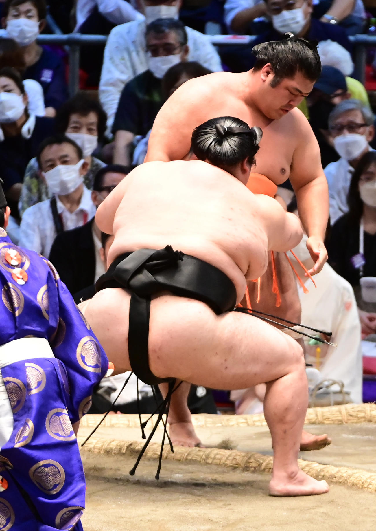 大奄美（手前左）は志摩ノ海を寄り切りで破る（撮影・小沢裕）