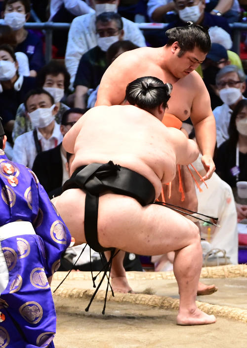 大奄美（手前左）は志摩ノ海を寄り切りで破る（撮影・小沢裕）