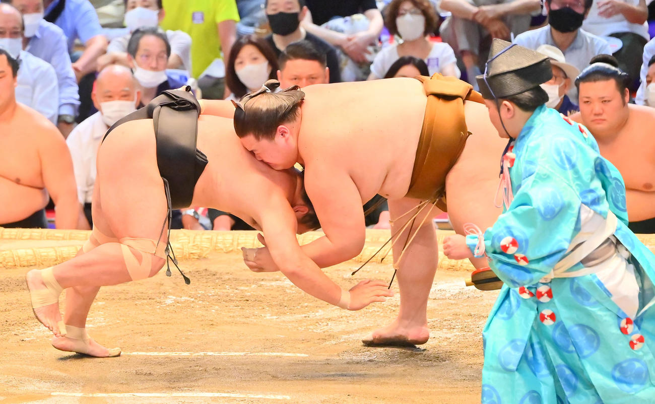照強（左）を上手出し投げで破る王鵬（撮影・和賀正仁）