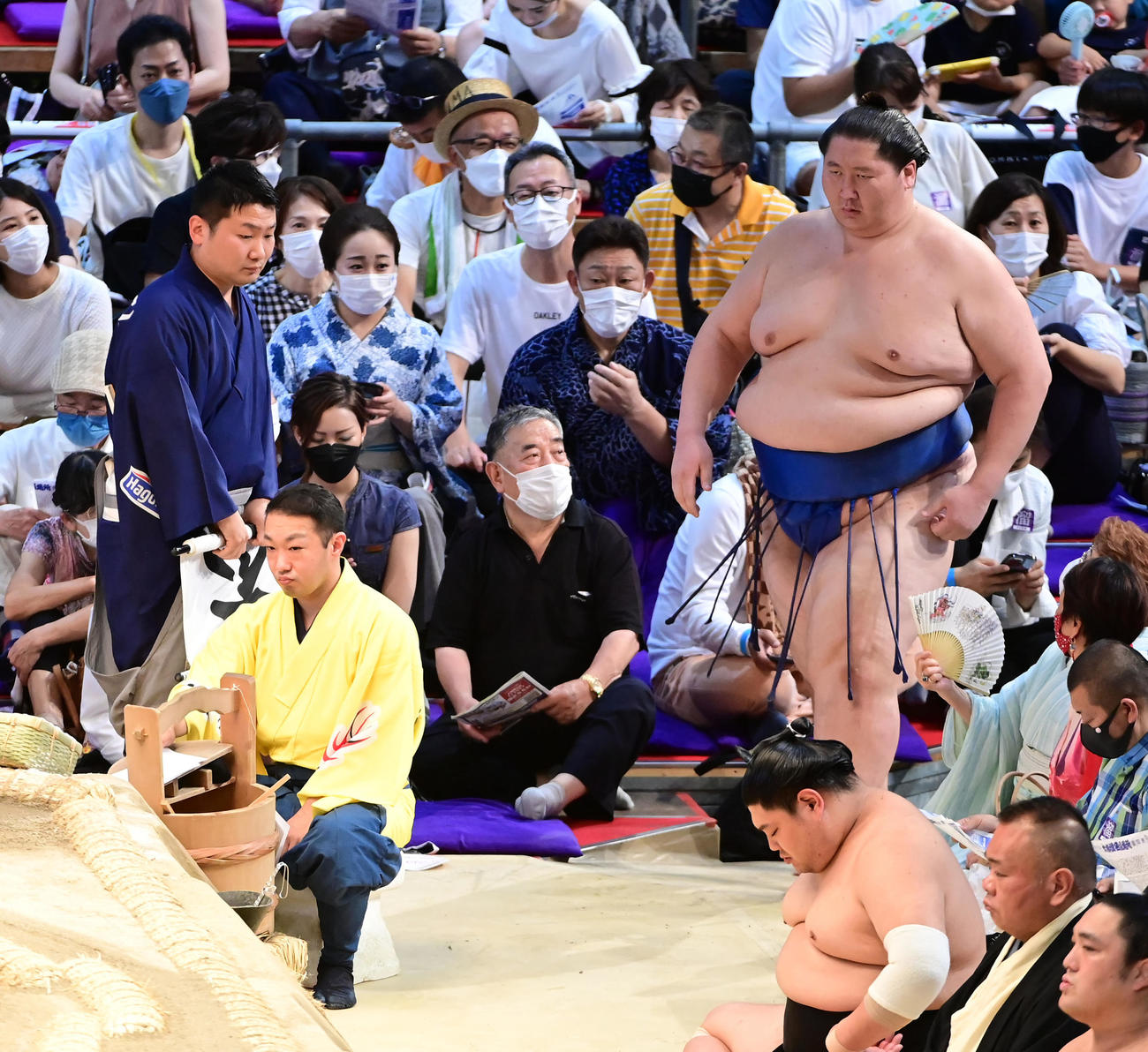 場内に掲げられた不戦勝の旗が呼出（左）に片付けられるなか勝ち名乗りを受けるため土俵に現れる逸ノ城（撮影・小沢裕）