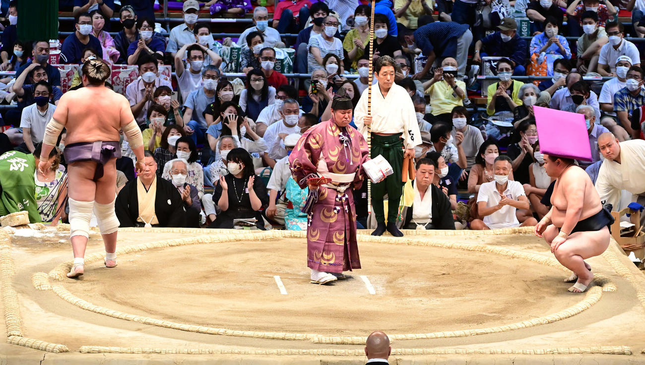 照ノ富士を引き落としで破った正代（右）に館内を舞った座布団が直撃する（撮影・小沢裕）