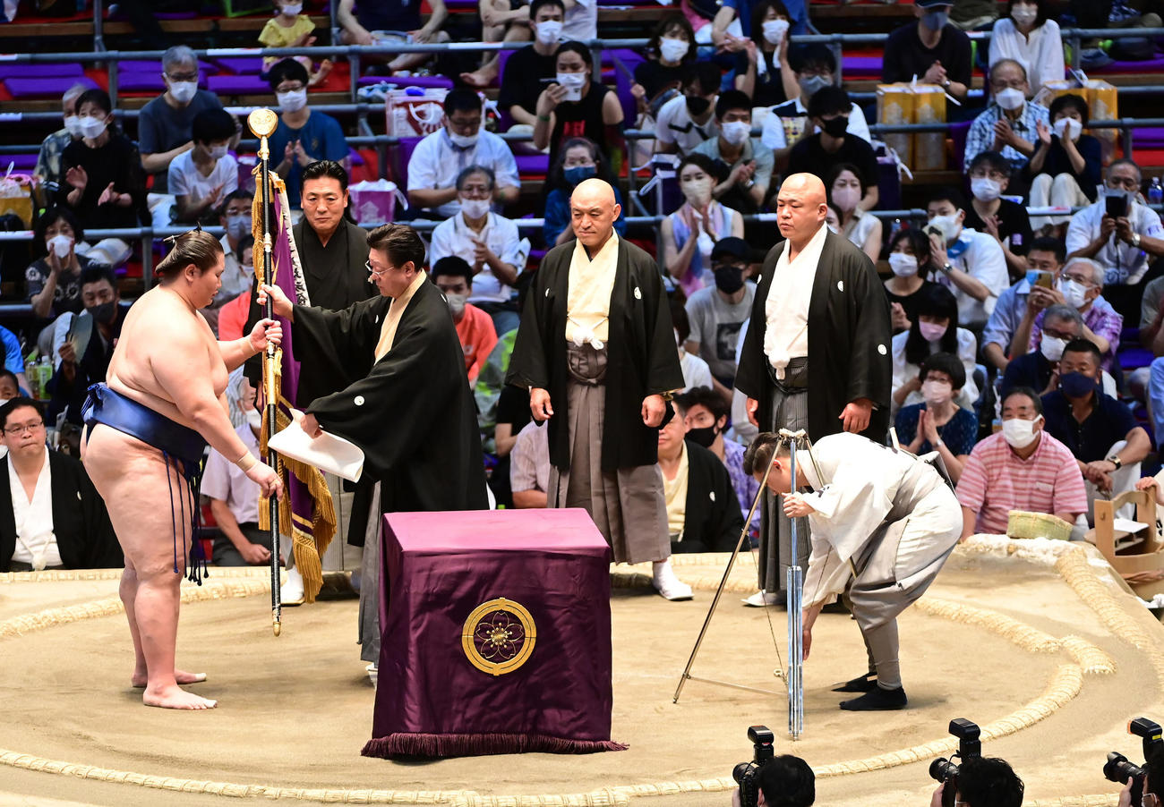 初優勝を飾った逸ノ城（左）は伊勢ケ浜審判部長から優勝旗の授与を受ける。左奥から陸奥事業部長、粂川審判部副部長、藤島同副部長（撮影・小沢裕）