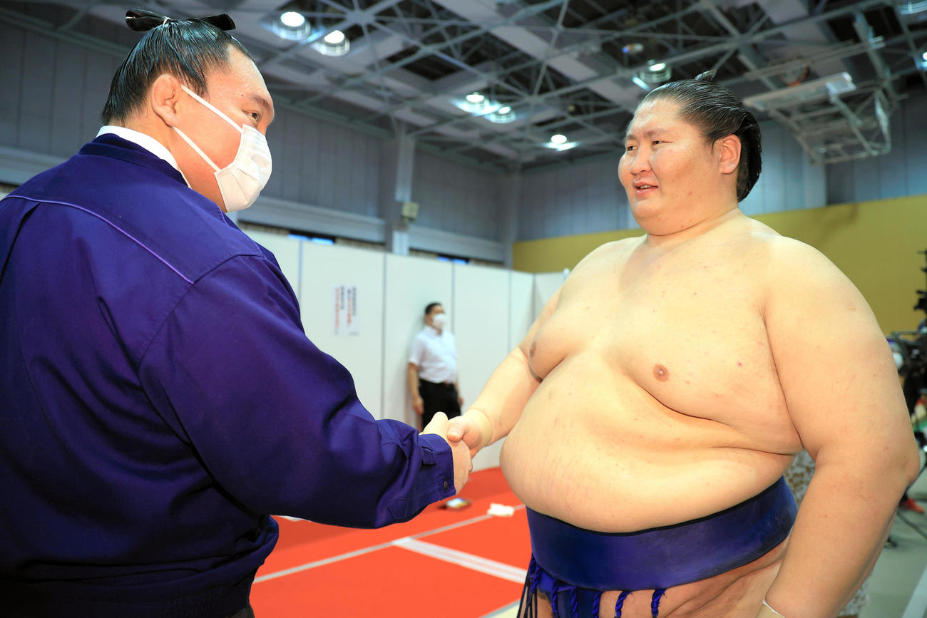 元横綱白鵬の間垣親方（左）と握手して初優勝を喜ぶ逸ノ城（代表撮影）