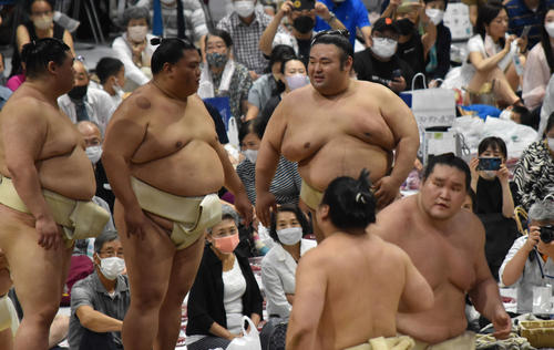 稽古中に言葉を交わす3大関。左から正代、御嶽海、貴景勝。手前右はぶつかり稽古で胸を出す照ノ富士