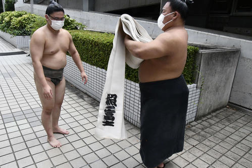 会場外で照ノ富士の稽古まわしをたたむ後輩力士たち（撮影・平山連）