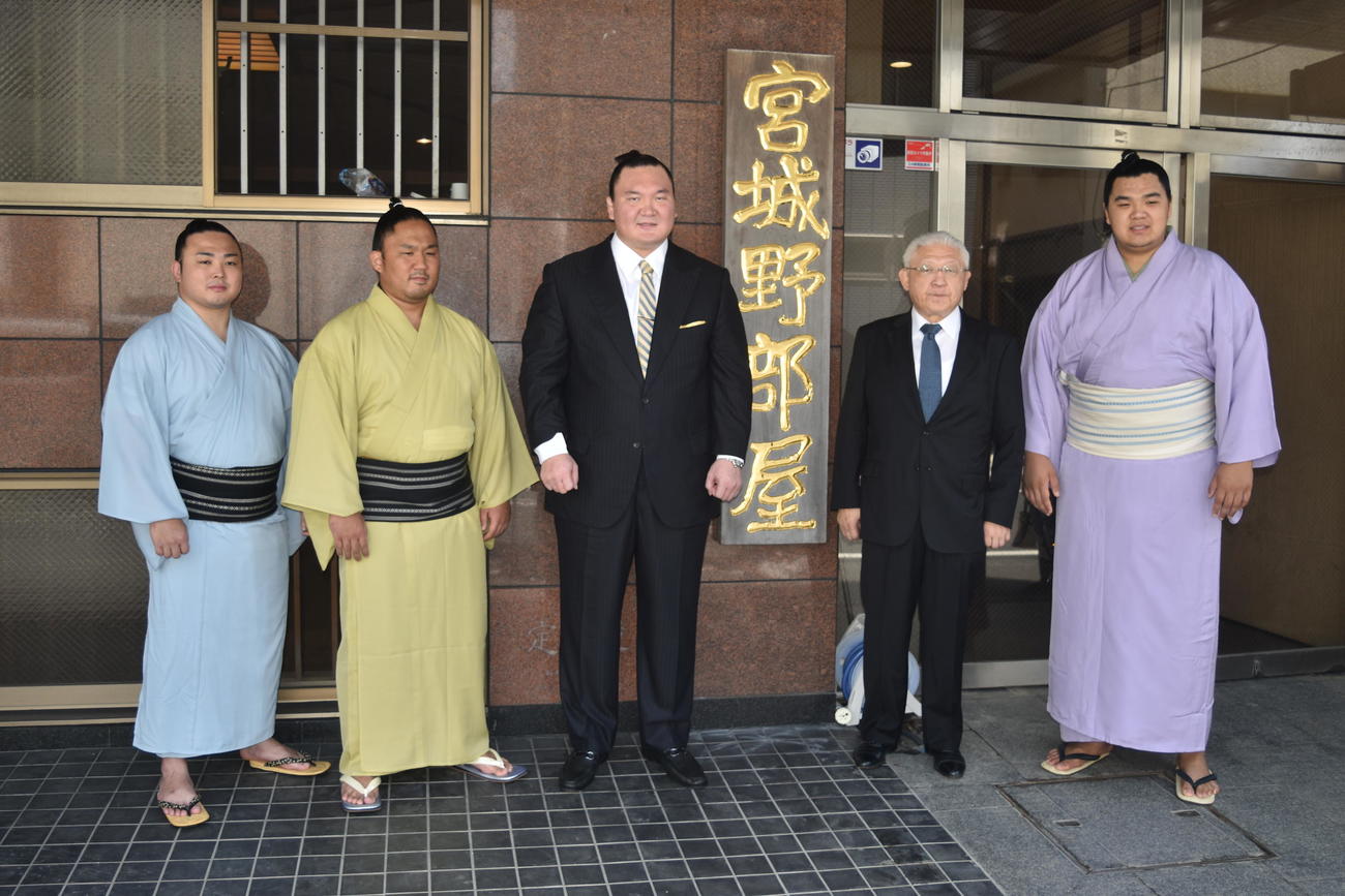 部屋の前で記念撮影に応じる宮城野親方（左から3人目）。左から炎鵬、石浦、1人おいて先代宮城野親方の間垣親方、北青鵬（2022年8月20日撮影）