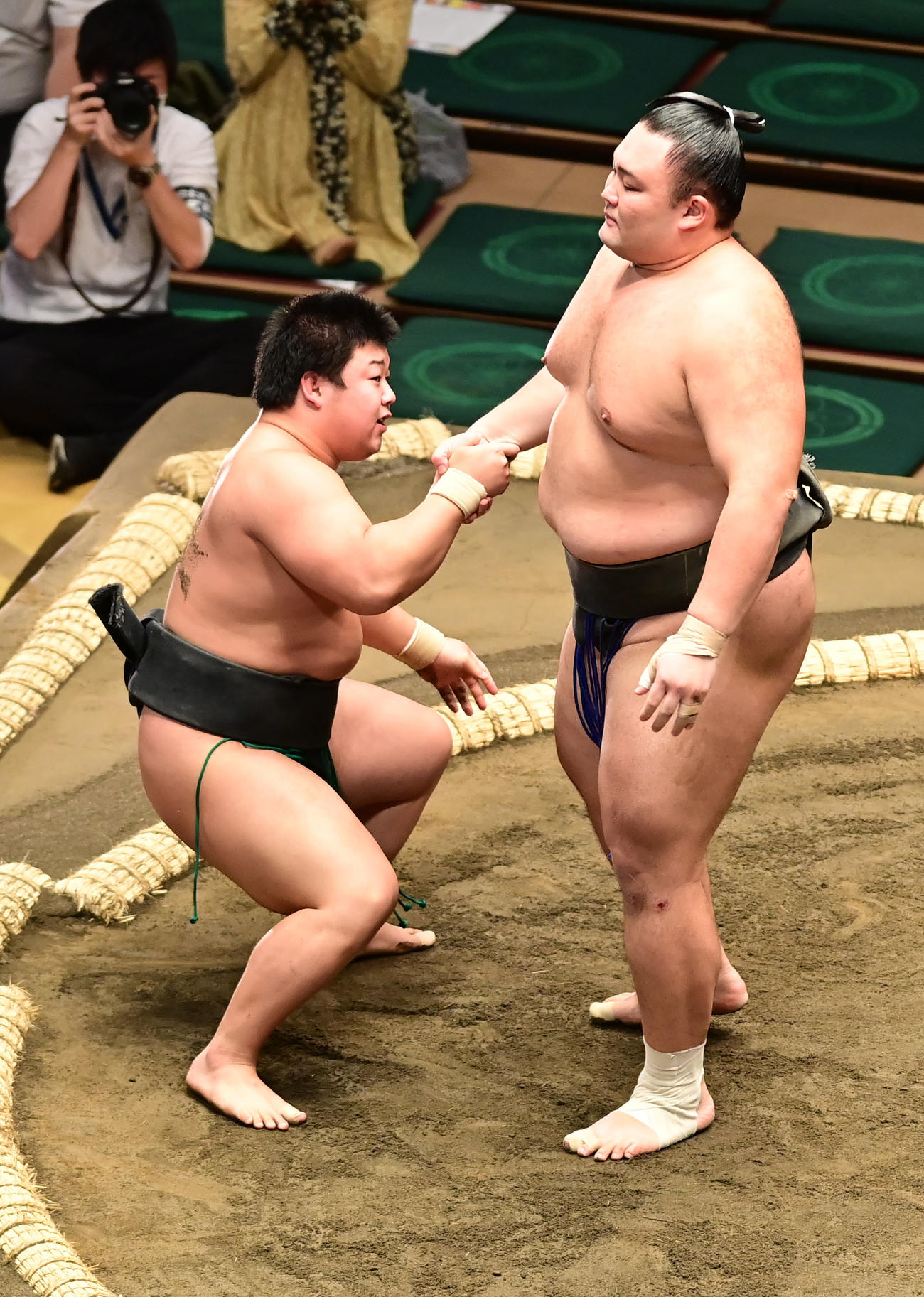 朝乃山（右）は寄り倒しで破った幕下付け出し格デビューの川副の手を取り、引き起こす（撮影・小沢裕）