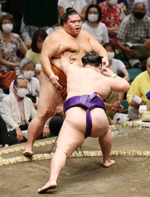 御嶽海（後方）は押し出しで明生に敗れる（撮影・宮地輝）