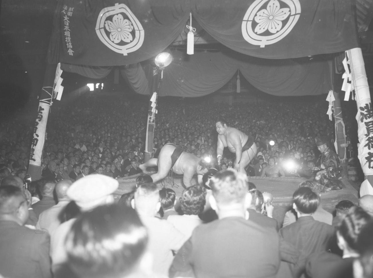 ４本柱があった時の土俵。夏場所13日目、西張出横綱東富士（右）が大関鏡里を引き落とした（1952年5月23日撮影）