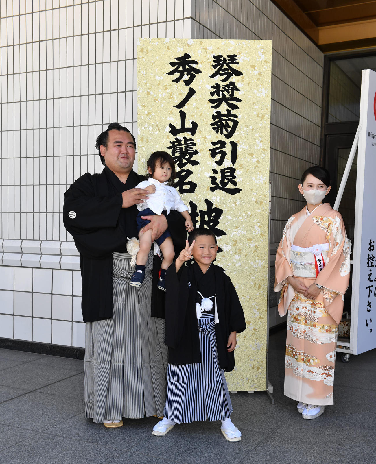 断髪式前の記念撮影　左から次男の将弘君を抱える元琴奨菊の秀ノ山親方、長男の弘人君、祐未夫人（代表撮影）