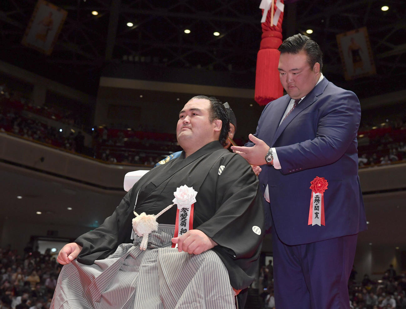 二所ノ関親方（元横綱稀勢の里＝右）にはさみを入れてもらう元琴奨菊の秀ノ山親方（代表撮影）