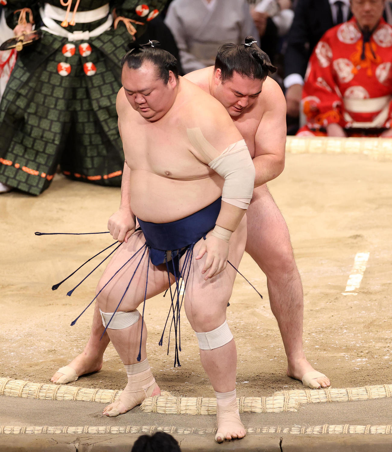 宝富士（手前）を送り出しで破る竜電（撮影・鈴木正人）