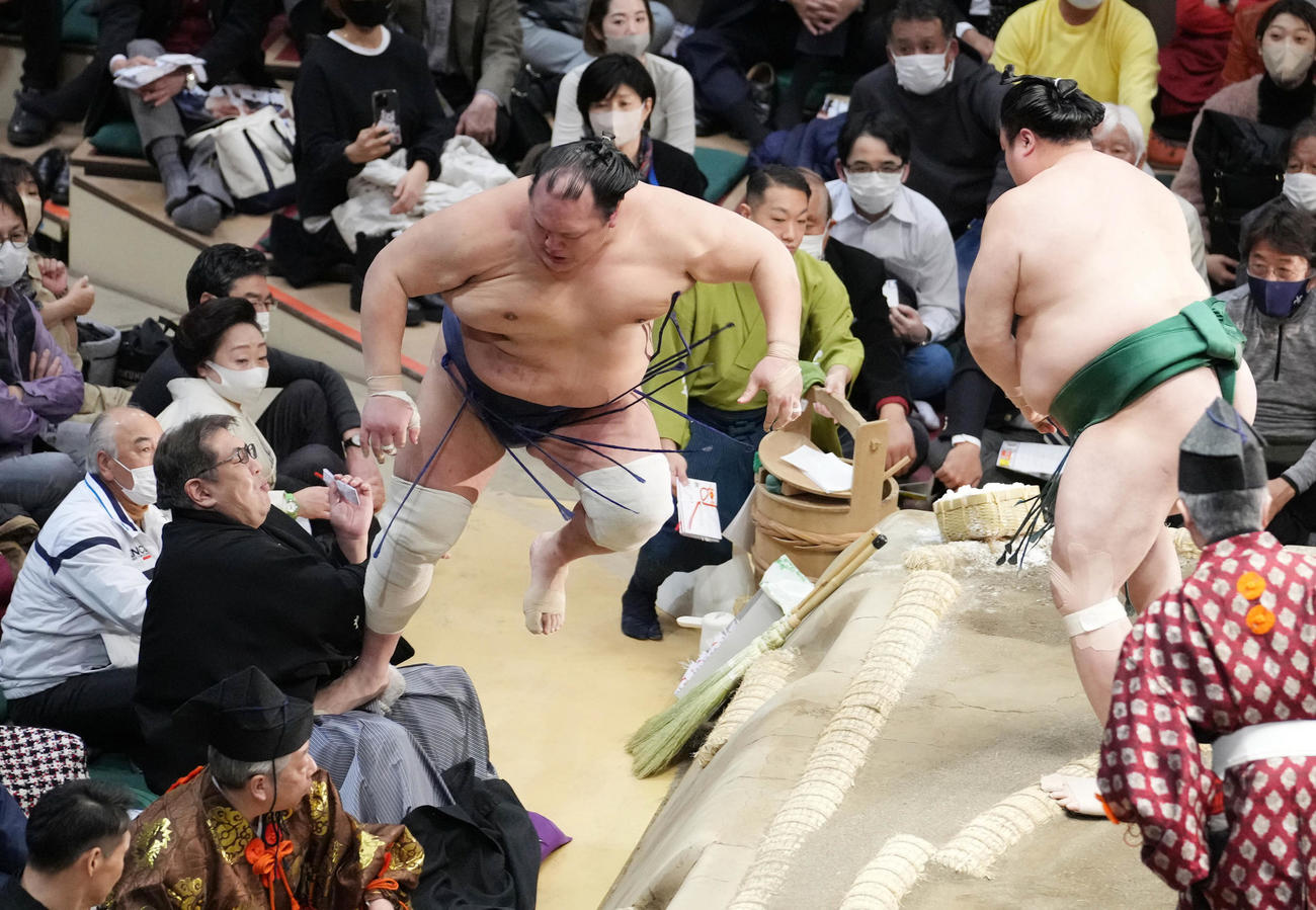 佐田の海（右）に押し出された北勝富士は勢いあまって審判を務める二子山親方の股間に着地する（撮影・小沢裕）