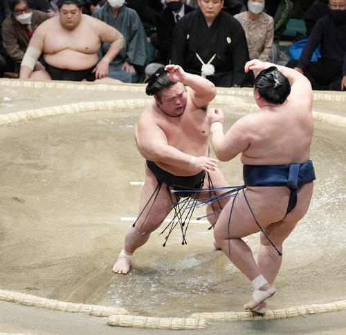 貴景勝は玉鷲（右）を押し出しで破る。左奥は土俵下で控える阿炎（撮影・小沢裕）