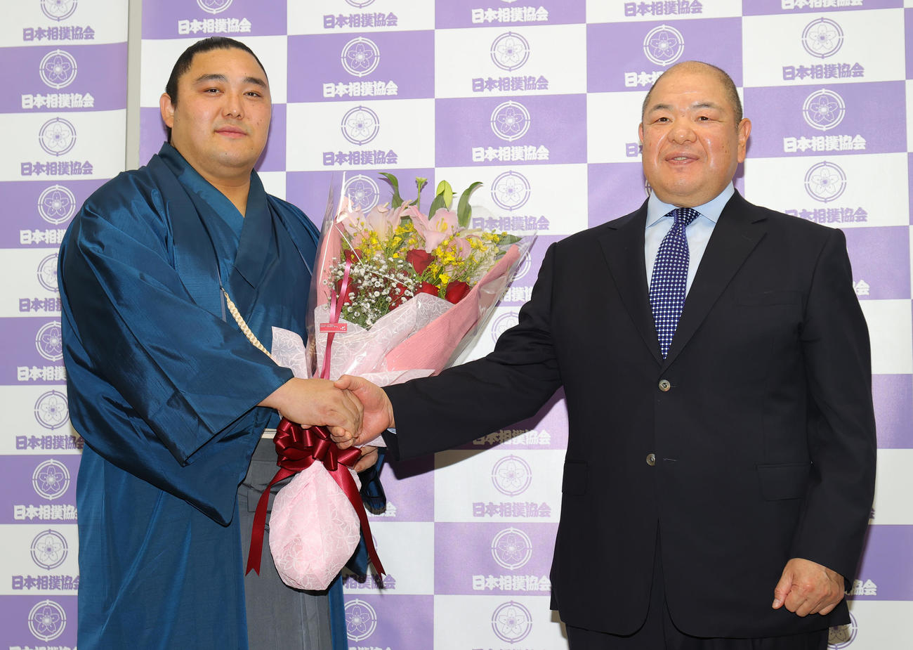 引退会見で八角親方（右）と握手する隠岐の海（撮影・野上伸悟）
