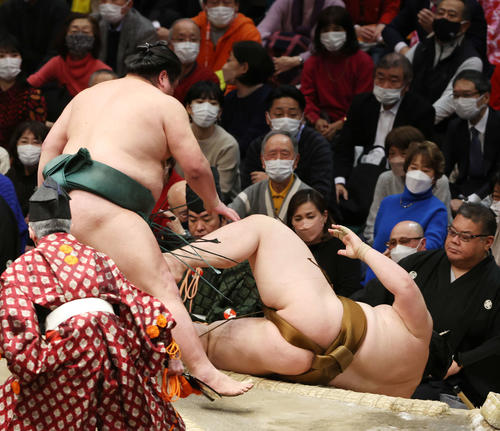 錦木（左）は寄り倒しで王鵬を破る（撮影・宮地輝）