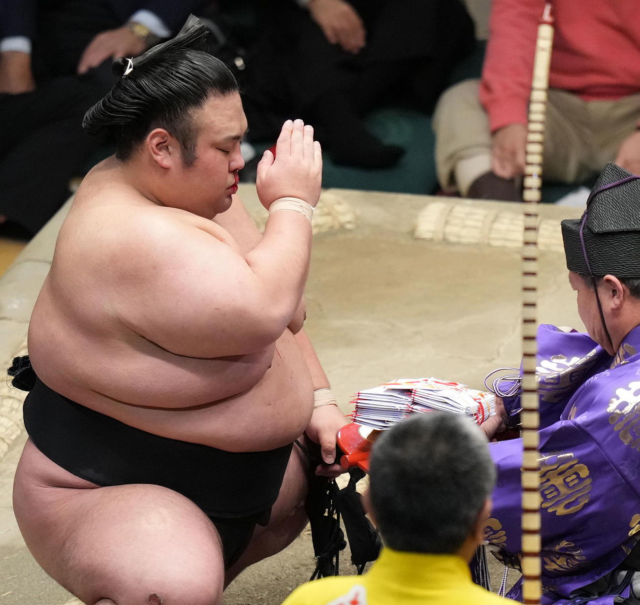 阿武咲を破り、鼻から流血したまま、懸賞金を受け取る貴景勝（撮影・狩俣裕三）