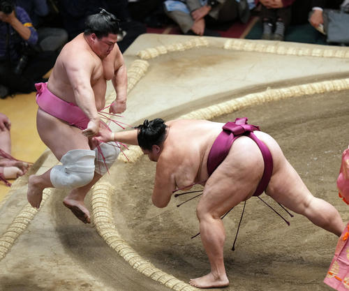宇良（左）を押し出しで破る御嶽海（撮影・狩俣裕三）