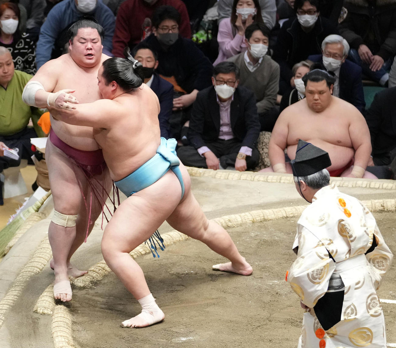 琴勝峰は大栄翔（左）を寄り切りで破る。右奥は控えに座る阿武咲（撮影・小沢裕）
