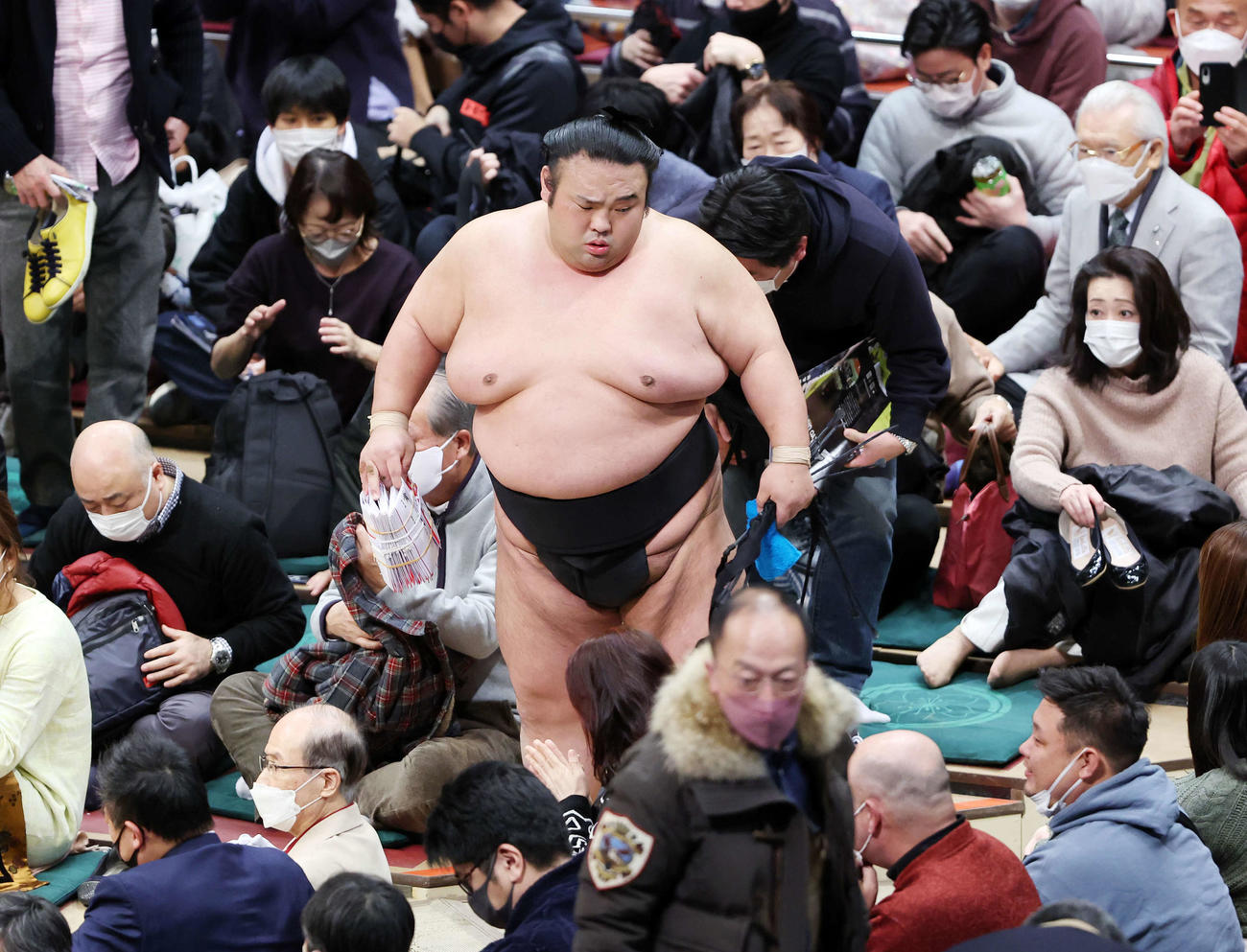 懸賞金の束を手に土俵を引き揚げる貴景勝（撮影・鈴木正人）