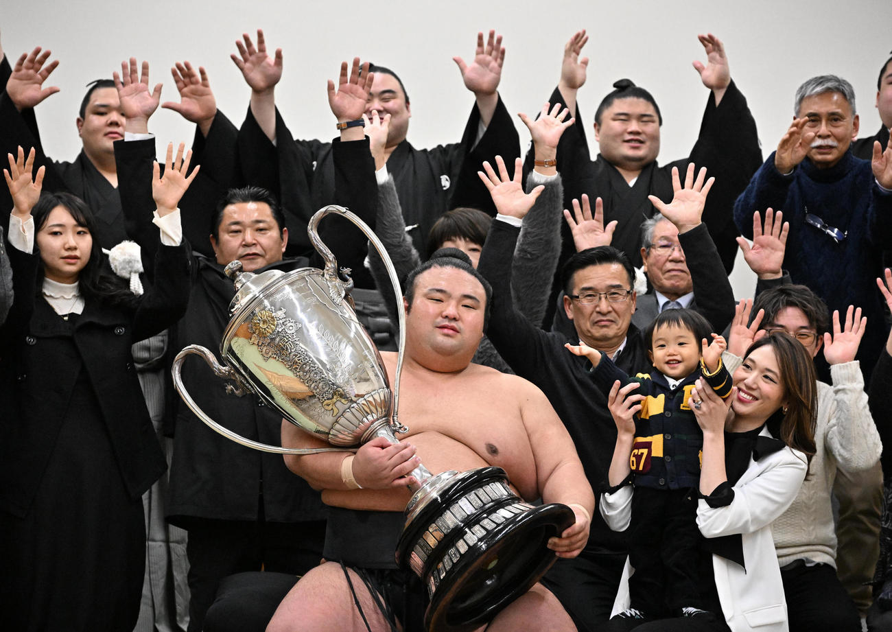 子どもを抱く有希奈夫人（右）ら家族や関係者に祝福される大関貴景勝（中央）（代表撮影）