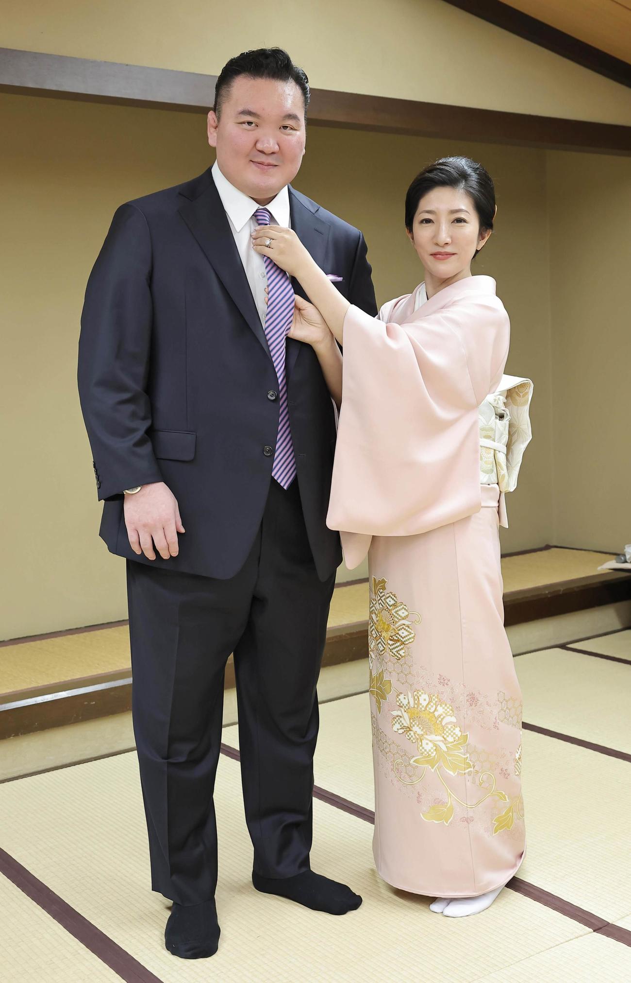 整髪を終えスーツに着替えた宮城野親方は紗代子夫人にネクタイを締めてもらう（23年1月28日、代表撮影）