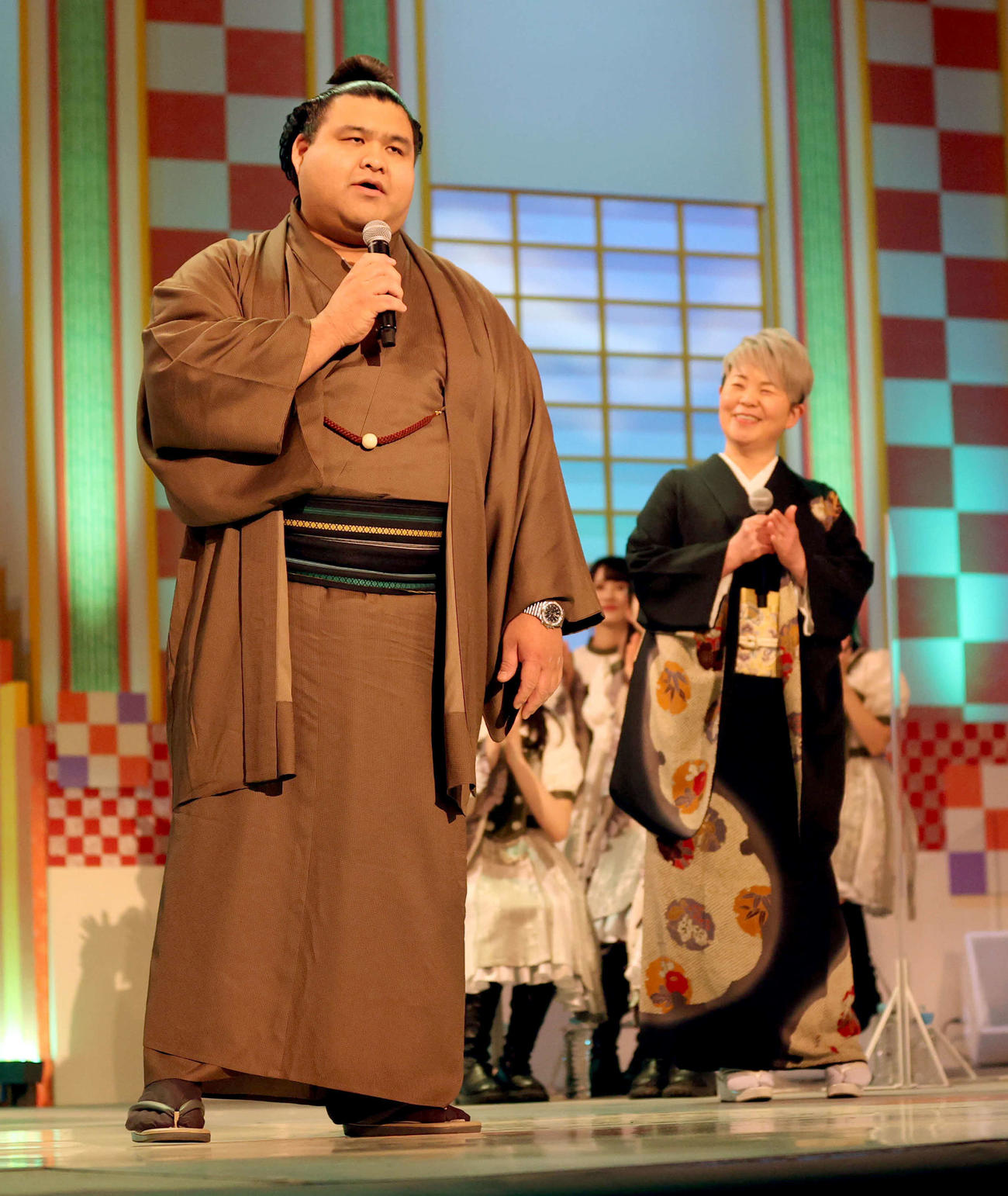 NHK福祉大相撲の「お楽しみ歌くらべ」コーナーで熱唱する高安。後方は歌手の島津亜矢（代表撮影）