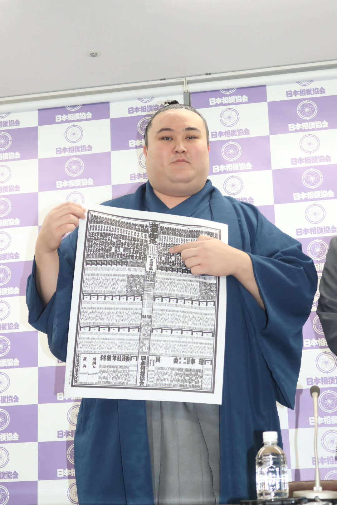 春場所の番付表の自分のしこ名を指さす新入幕の金峰山（日本相撲協会提供）