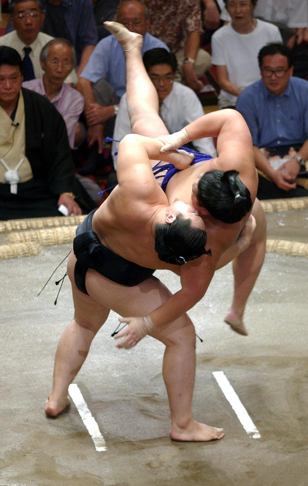 【吊り落とし】朝青龍（左）は北勝力を相手に大技吊り落としを豪快に決める（2003年9月12日撮影）