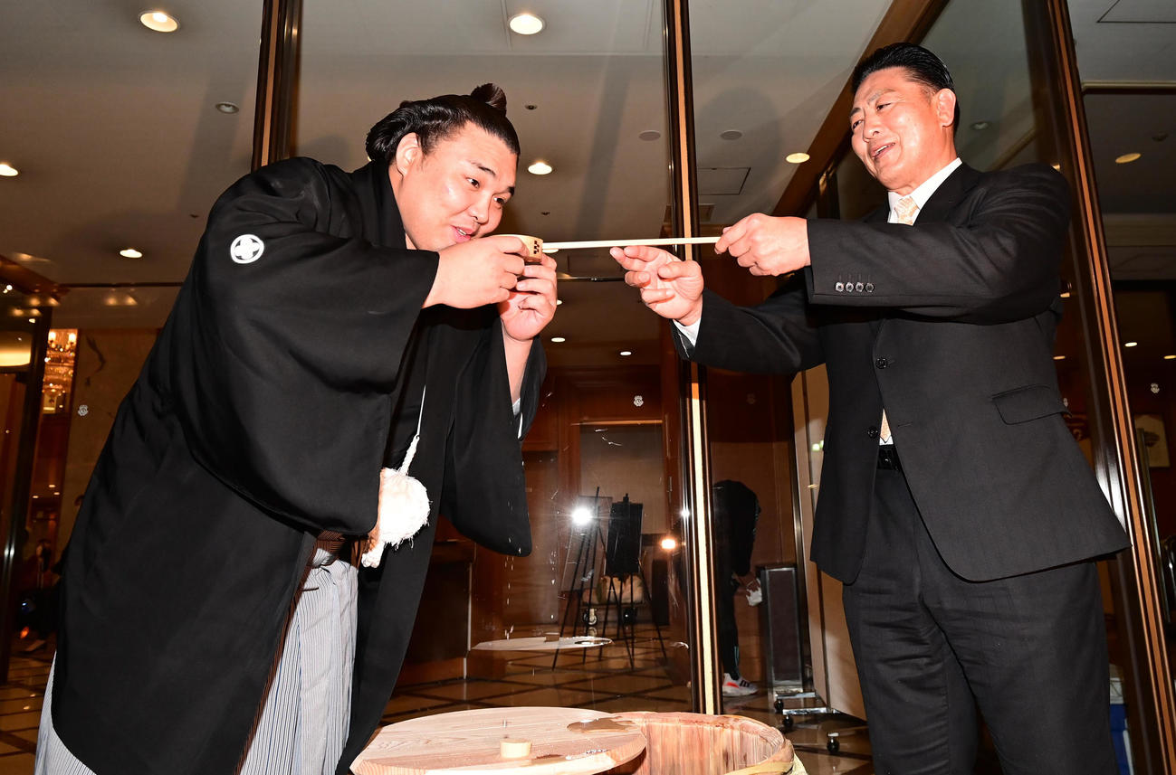 幕内初優勝を決めた霧馬山（左）は祝勝会会場のホテル前で陸奥親方から水付けを受ける（撮影・小沢裕）