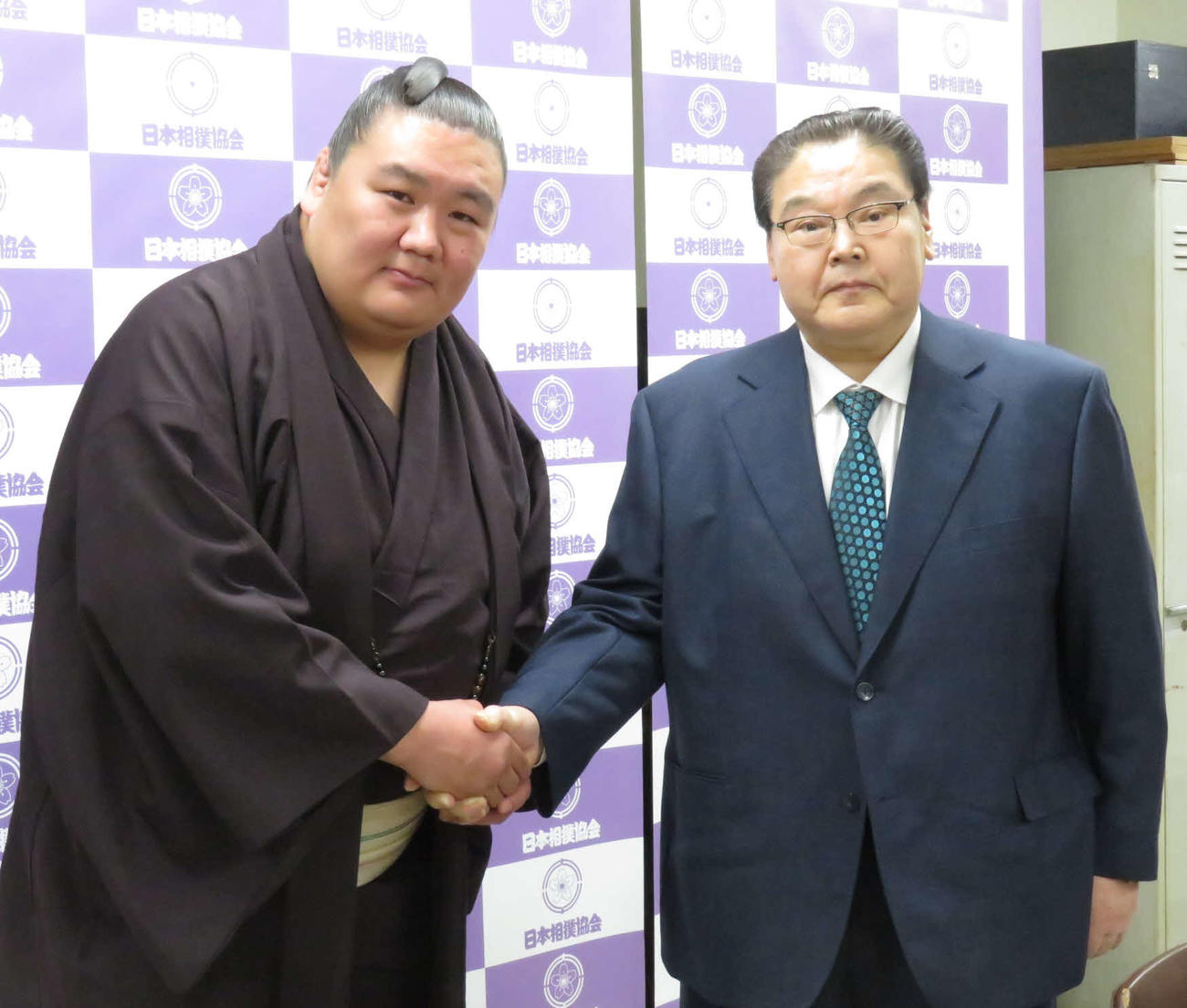 引退会見後、握手を交わす元鏡桜（左）と入門時の師匠の鏡山親方
