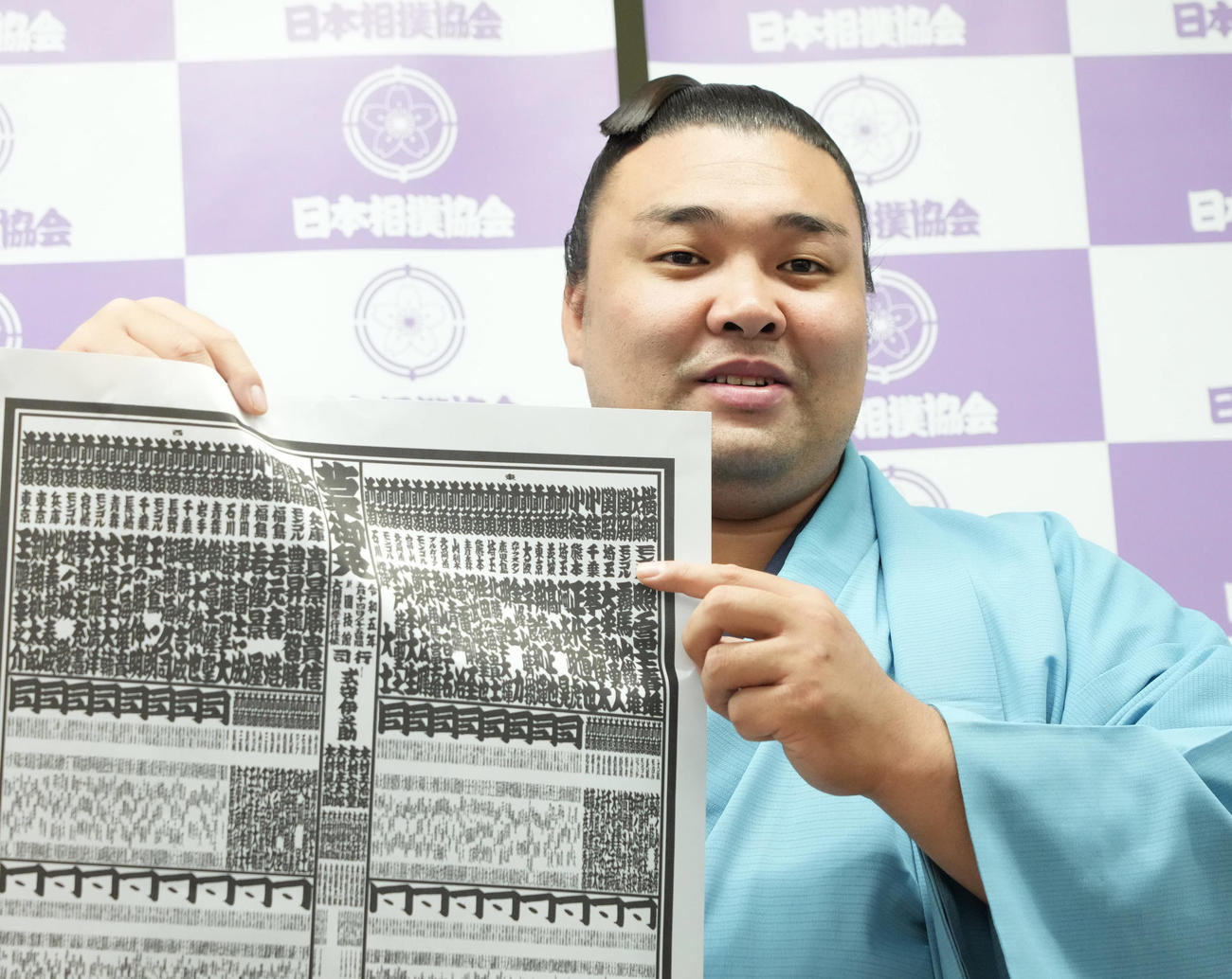 大相撲夏場所の番付発表で自らの名前を指し笑顔を見せる霧馬山（撮影・小沢裕）
