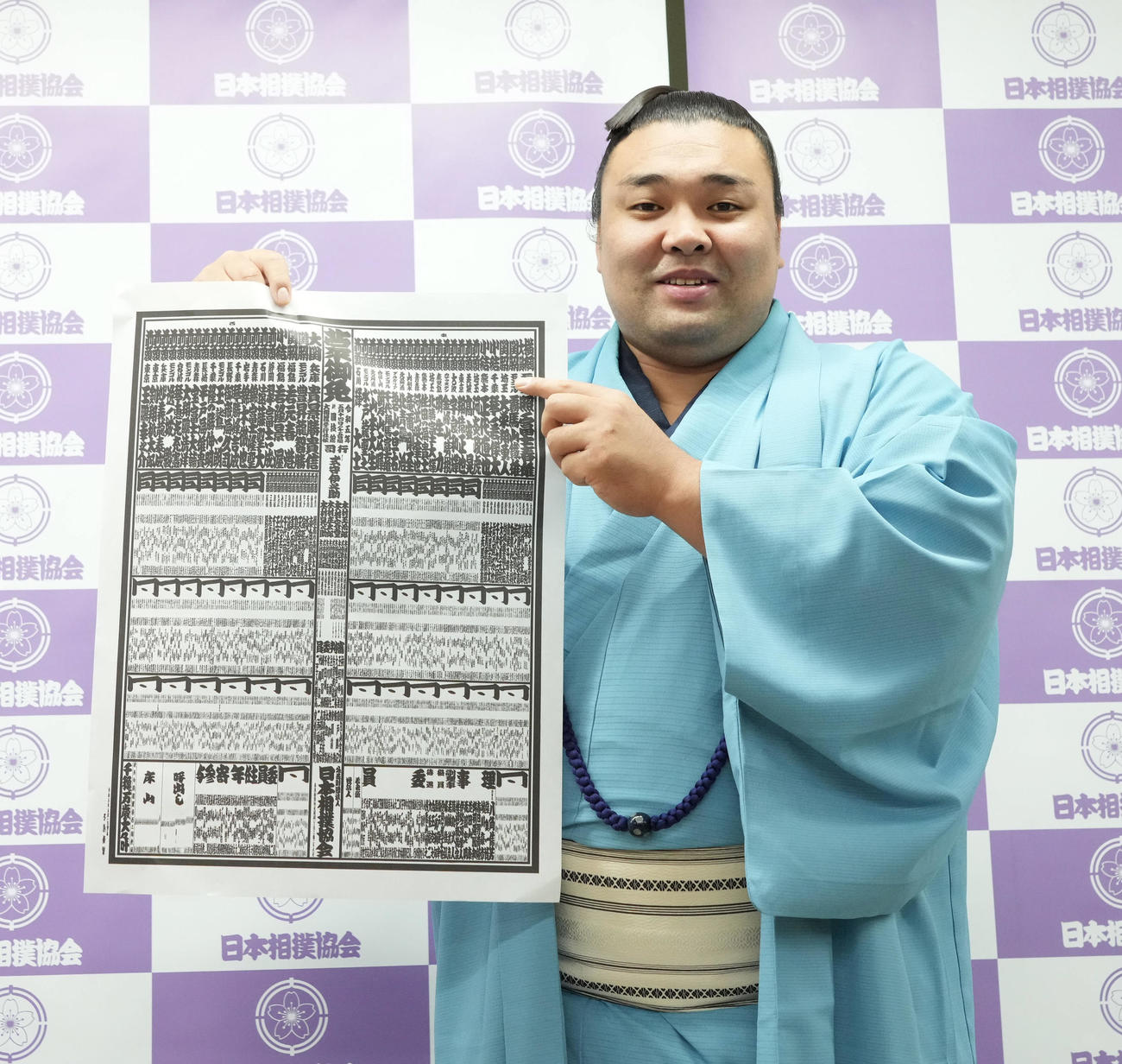 大相撲夏場所の番付発表で自らの名前を指し笑顔を見せる霧馬山（撮影・小沢裕）