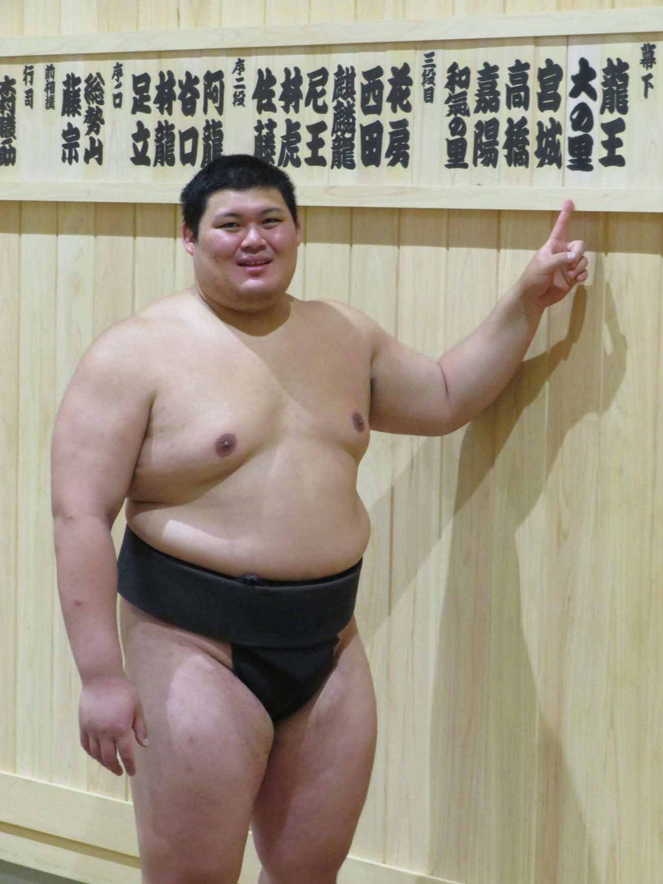 稽古後、自身の木札を指さして笑顔を見せる大の里