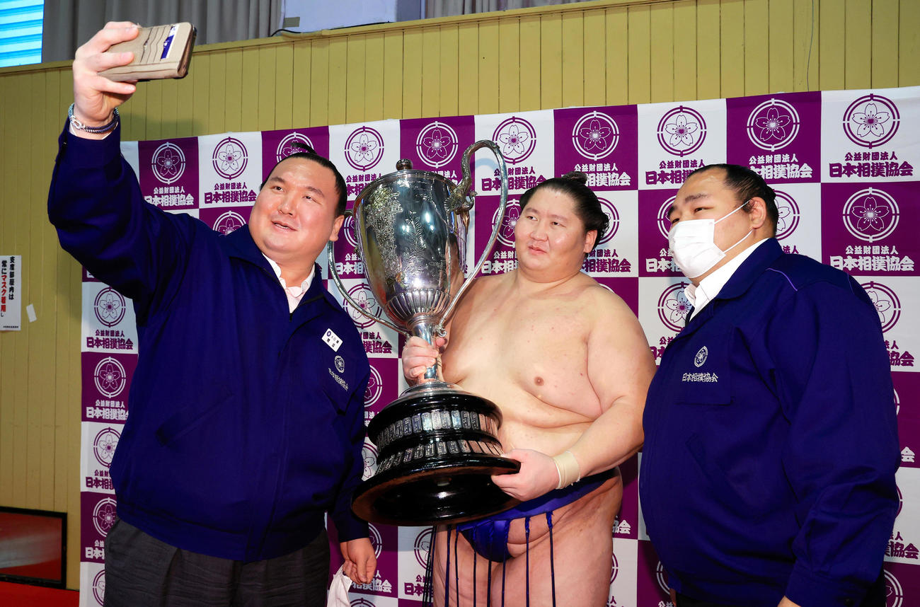 22年7月、元横綱白鵬の間垣親方（左）はスマートフォンで初優勝の逸ノ城（中央）と記念撮影。右は右は元横綱鶴竜