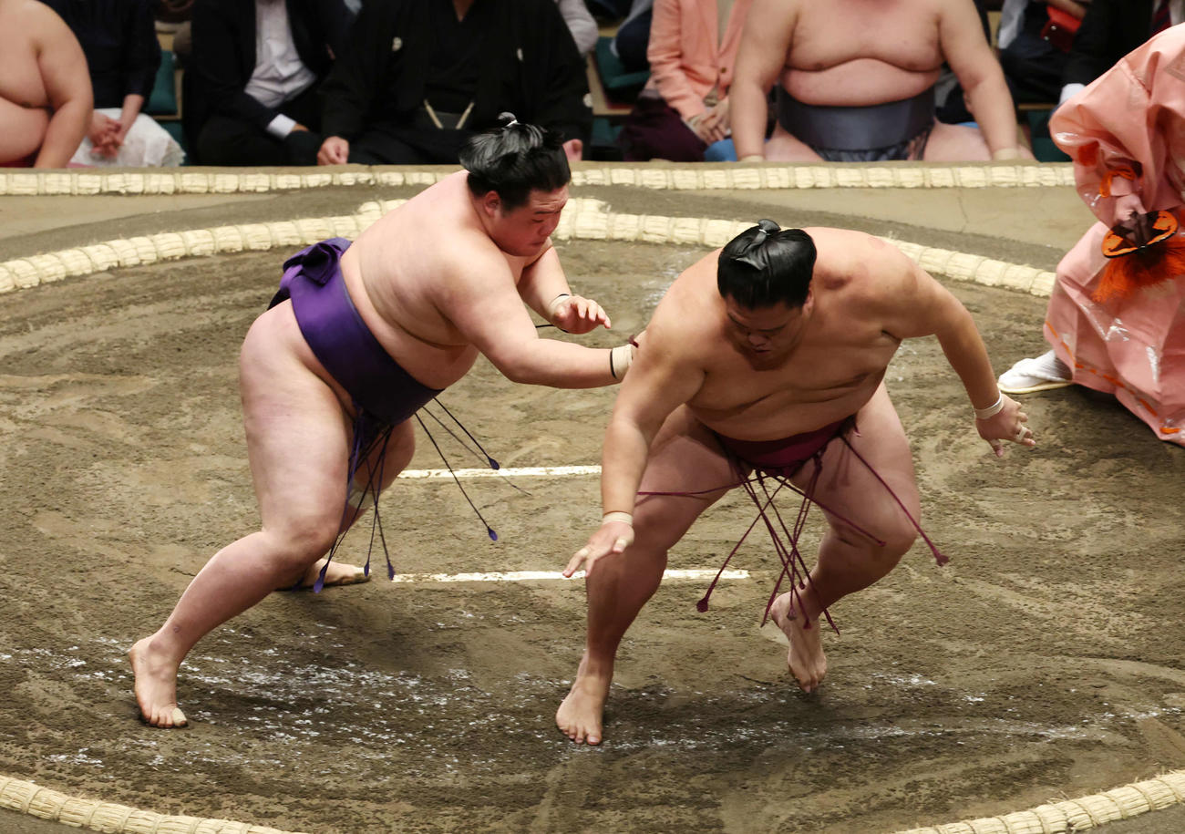 送り出しで御嶽海（右）を破る明生（撮影・宮地輝）