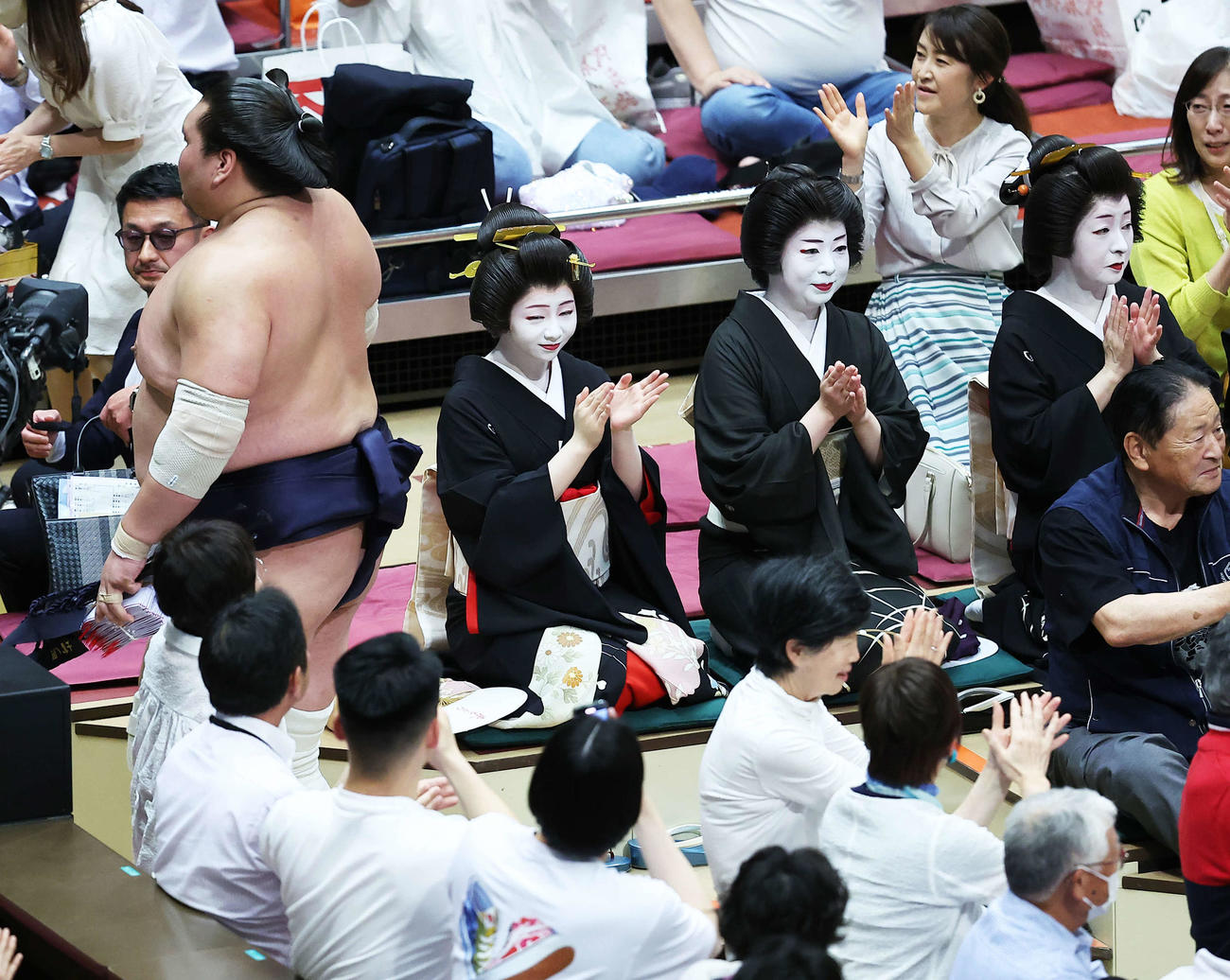 遠藤を押し出しで下し、懸賞金の束を手に土俵から引き揚げる照ノ富士（左）（撮影・河田真司）