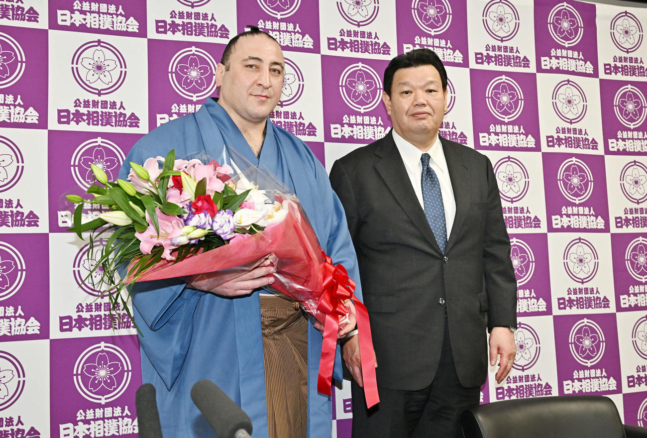 引退会見を終えた栃ノ心（左）は花束を手に春日野親方と記念撮影する（撮影・滝沢徹郎）