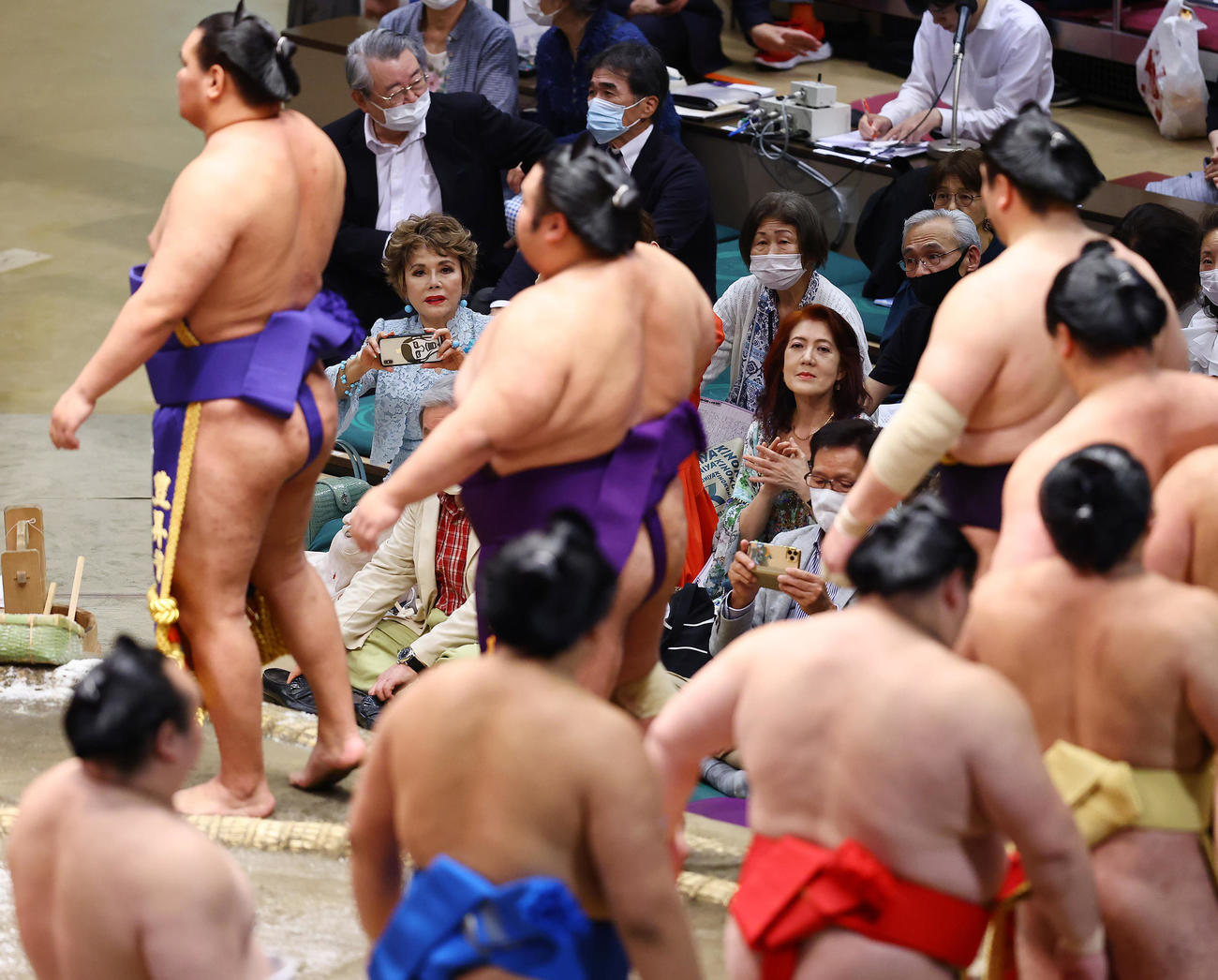 土俵に上がる幕内力士たちの写真を撮るデヴィ夫人（左奥）（撮影・垰建太）