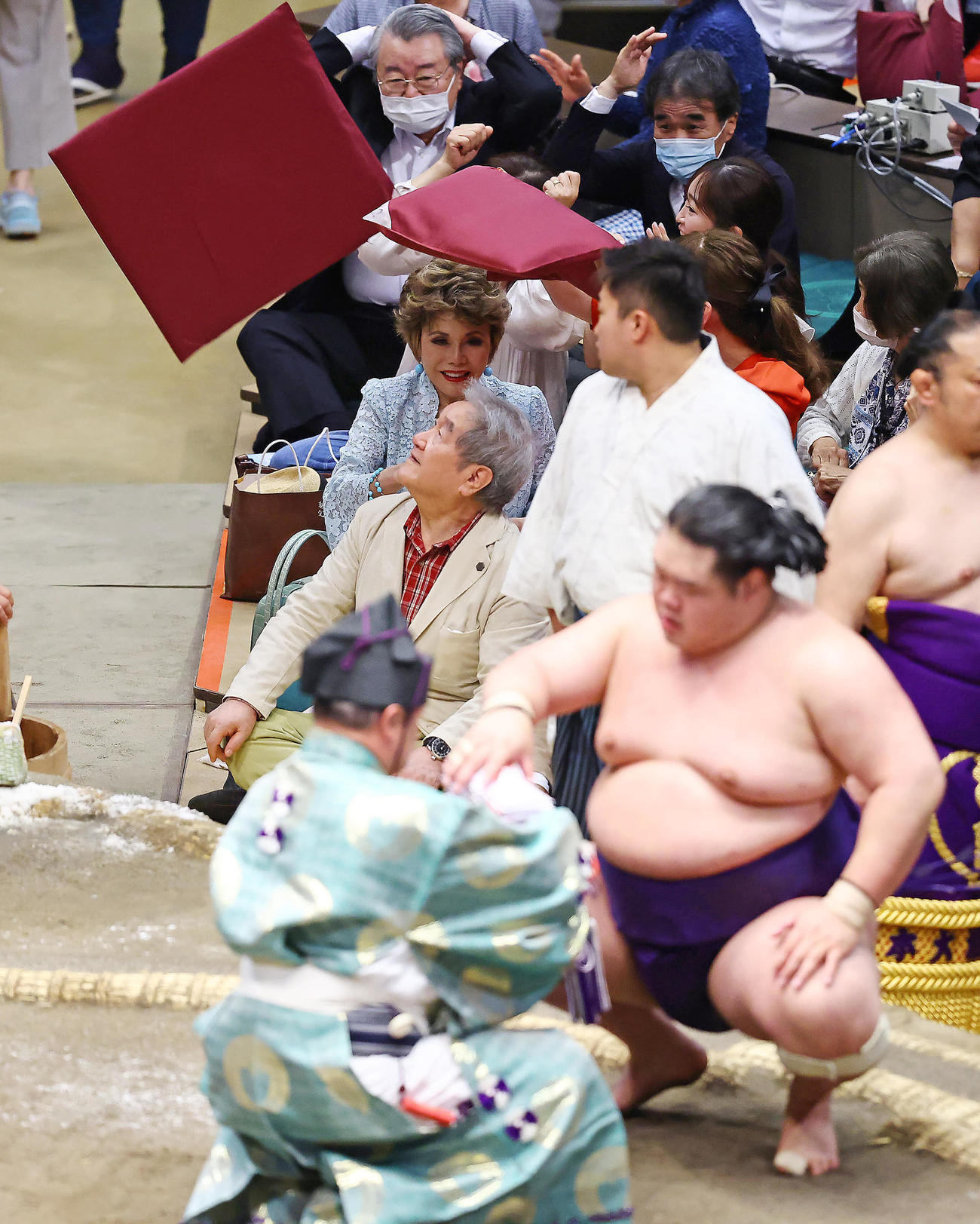 明生（手前）が照ノ富士を破り座布団が舞う両国国技館でデヴィ夫人は笑顔を見せる（撮影・垰建太）