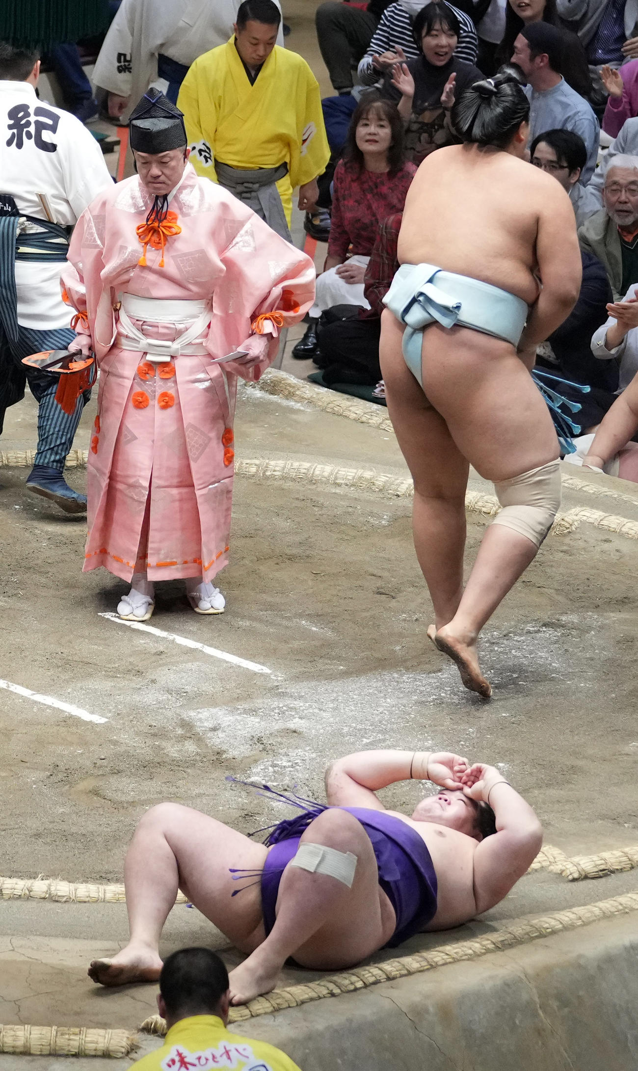 北青鵬に上手投げで敗れた明生（手前）は土俵に仰向けになりながら頭を抱える（撮影・小沢裕）