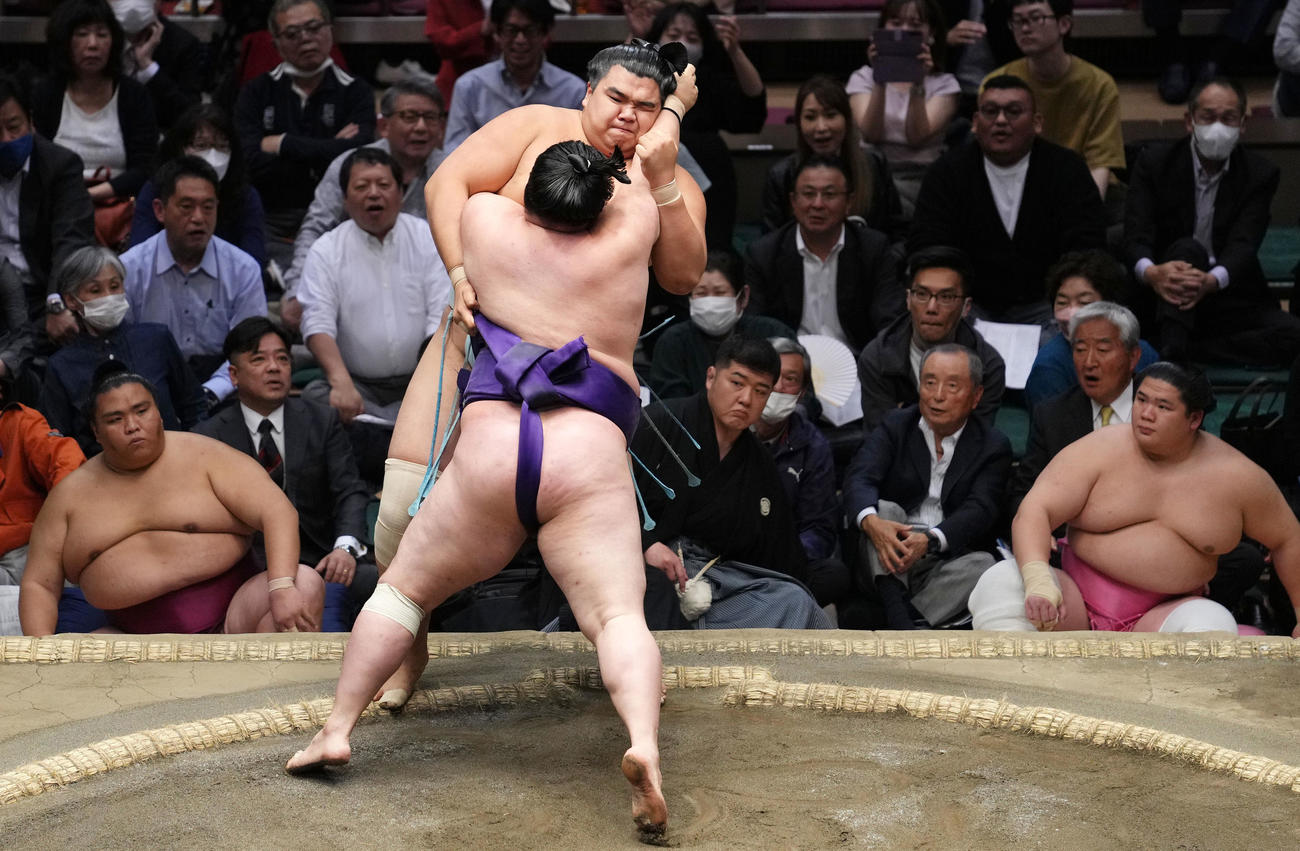 明生（手前）の攻めを土俵際で持ちこたえる北青鵬（撮影・横山健太）