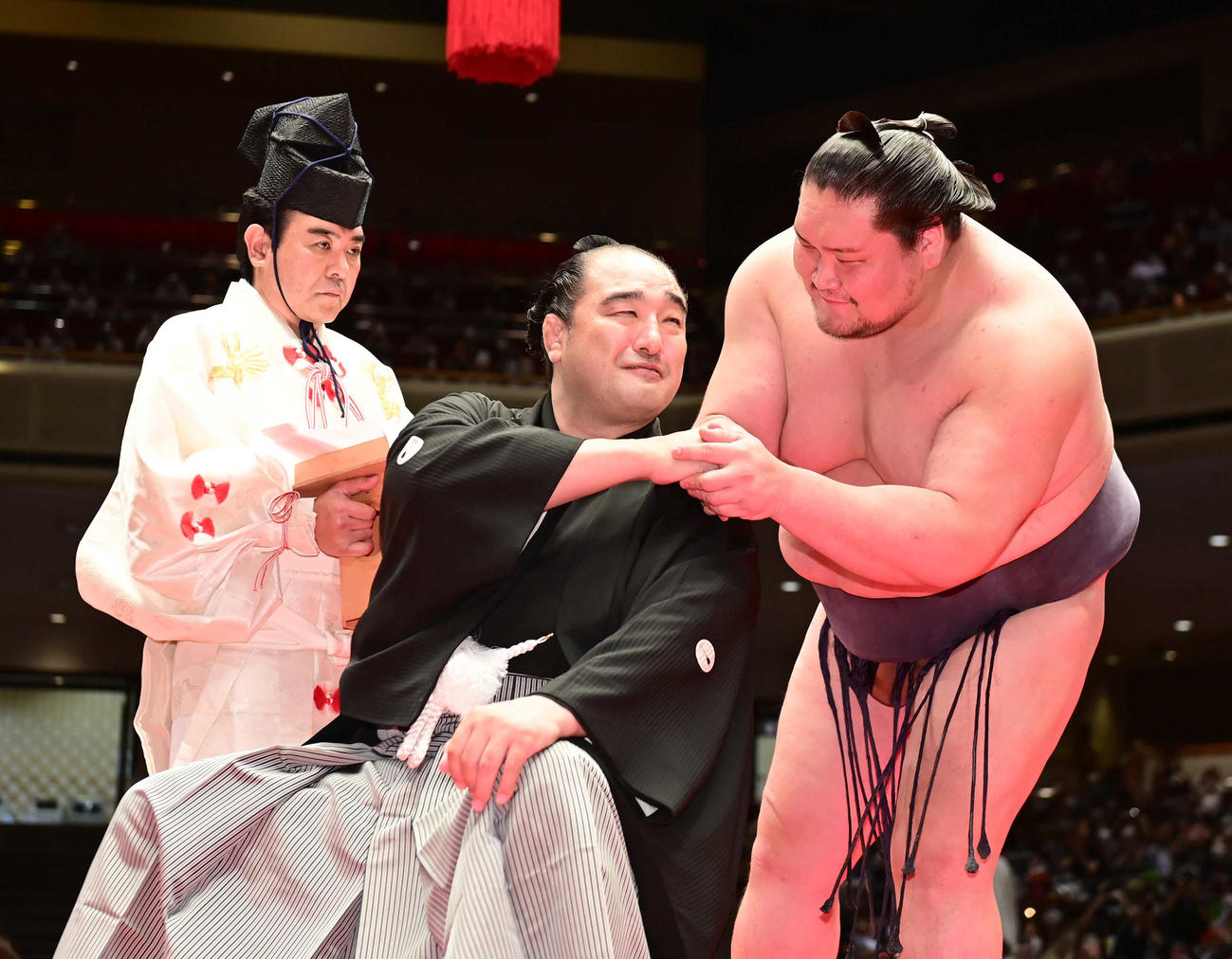 断髪式ではさみを入れてくれた照ノ富士（右）と握手をかわす元安美錦の安治川親方（2022年5月撮影）
