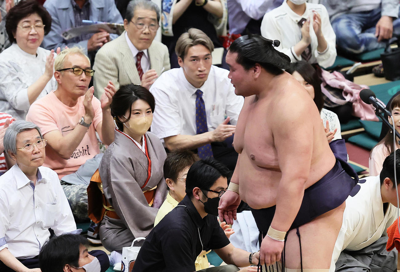 照ノ富士（右）の優勝インタビューに拍手を送る所ジョージ（中央左）と格闘家の安保瑠輝也（同右）（撮影・足立雅史）