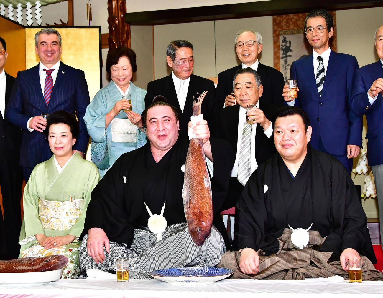 大関昇進伝達式を終えた栃ノ心（中央）はお祝いの鯛を手に、前列左から春日野親方の紀子夫人、1人おいて先代春日野親方、春日野親方ら関係者と記念撮影に臨む（2018年5月30日撮影）
